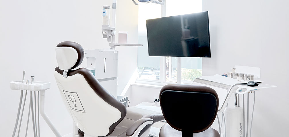A treatment chair and screen at the clinic, where records are reviewed with you.